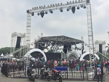 Pengunjung beraktivitas di sekitar panggung hiburan untuk perayaan malam Tahun Baru di Monas, Jakarta, Sabtu (30/12). Pemprov DKI Jakarta menjadikan monas sebagai tempat pusat perayaan pergantian malam Tahun Baru 2018. (Liputan6.com/Immanuel Antonius)