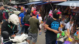 Warga memilih mainan tanpa menjaga jarak di Pasar Gembrong, Jakarta Timur, Minggu (31/5/2020). Meski penerapan masa Pembatasan Sosial Berskala Besar (PSBB) di Jakarta masih berlaku, namun pasar yang khusus menjual pernak-pernik mainan anak ini kembali dipadati warga. (Liputan6.com/Immanuel Antonius)