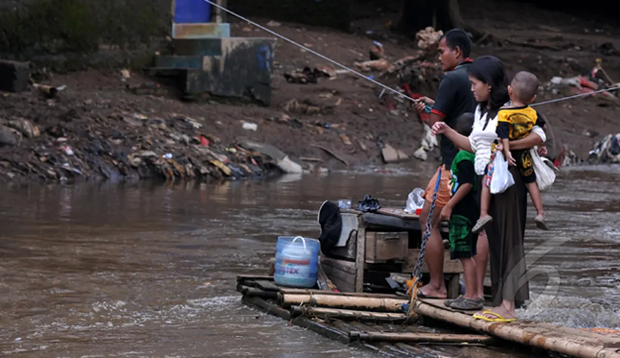 Masih banyak warga bantaran kali Ciliwung Jakarta yang memanfaatkan air kali untuk kehidupan sehari - hari. Tampak aktivitas warga saat menyebrangi kali Ciliwung, Jakarta, Jumat (20/2/2015). (Liputan6.com/JohanTallo)
