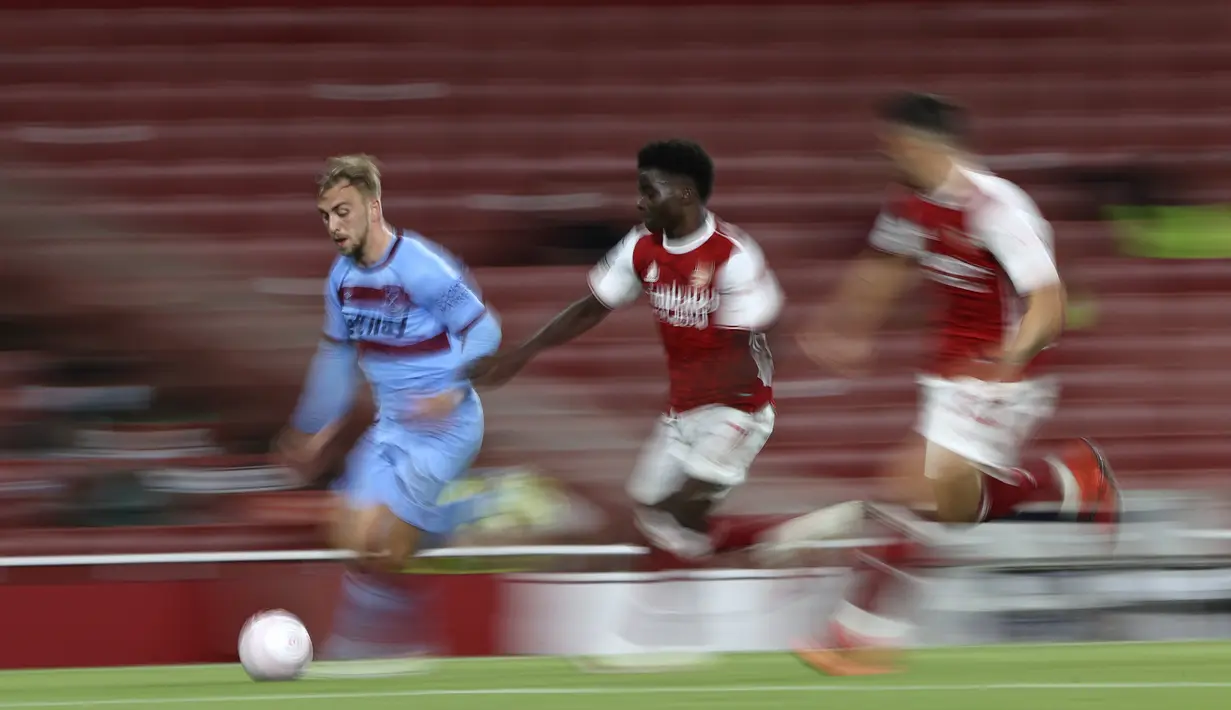 Penyerang West Ham,  Jarrod Bowen membawa bola dari kejaran gelandang Arsenal, Bukayo Saka pada pertandingan lanjutan Liga Inggris di Stadion Emirates di London, Inggris, Sabtu (19/9/2020). Arsenal menang tipis 2-1 atas West Ham. (AP Photo/Ian Walton, Pool)