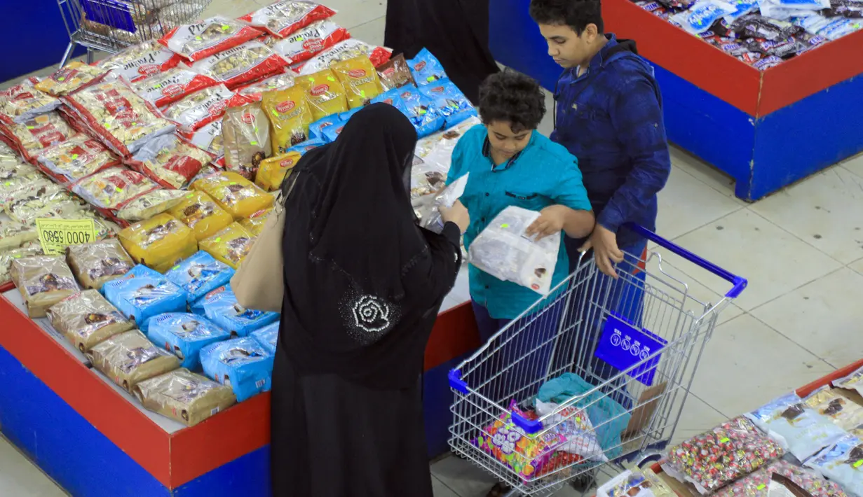 Warga Yaman membeli permen dan kacang-kacangan saat umat Islam bersiap untuk merayakan liburan tahunan Idul Adha (Hari Raya Kurban) di supermarket di ibu kota Sanaa (18/7/2021). (AFP/Mohammed Huwais)