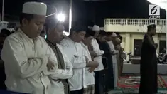 Puluhan warga menggelar salat gerhana bulan, di emperan salah satu kantor perbankan.