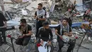 Musisi Palestina tampil di puing-puing Menara Hanadi di Kota Gaza (2/6/2021). Acara diselenggarakan oleh Komite Pemuda dan Kebudayaan Palestina lebih dari seminggu setelah gencatan senjata mengakhiri 11 hari permusuhan antara Israel dan Hamas. (AFP Photo/Mohammed Abed)