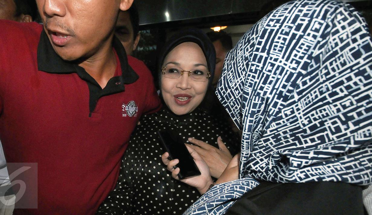 Sylviana Murni dikawal ketat saat meninggalkan gedung Ombudsman usai menjalani pemeriksaan Dir Tipikor Bareskrim Polri, Jakarta, Rabu (2/1). Ia diperiksa sebagai saksi dugaan korupsi dana hibah Kwarda Pramuka Jakarta. (Liputan6.com/Helmi Fithriansyah)