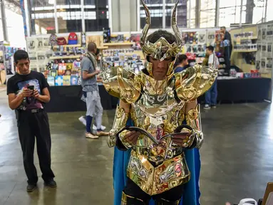 Cosplay mengenakan kostum saint saiya membaca komik selama Comic Con Colombia 2018 di Medellin (16/11). Comic Con Colombia menyatukan penggemar dan pengusaha dari industri hiburan dan permainan berlangsung 16-18 November. (AFP Photo/Joaquin Sarmiento)