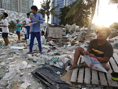 Anak-anak bermain layang-layang di tempat pembuangan limbah bangunan di Gandaria, Jakarta, Jumat (4/3). Keterbatasan lahan bermain membuat anak-anak tersebut terpaksa menghabiskan waktu di tempat yang tidak semestinya. (Liputan.com/Immanuel Antonius)