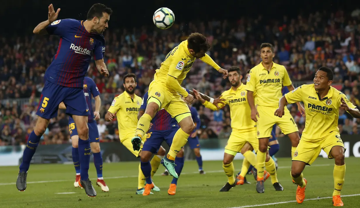 Aksi pemain FC Barcelona, Sergio Busquets (kiri) saat menyundul bolake gawang Villareal pada laga La Liga Santander di Camp Nou stadium, Barcelona, (9/5/2018). Barcelona menang telak 5-1. (AP/Manu Fernandez)
