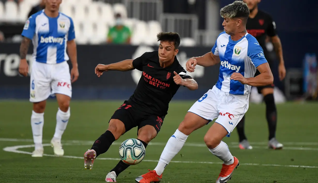 Gelandang Sevilla, Olivier Torres, berebut bola dengan penyerang Leganes, Javier Aviles, pada laga lanjutan La Liga pekan ke-33 di Estadio Municipal de Butarque, Rabu (1/7/2020) dini hari WIB. Sevilla menang 3-0 atas Leganes. (AFP/Pierre-Philippe Marcou)