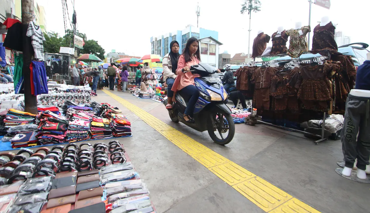 Pengendara motor melintas diatas trotoar yang samping kanan-kirinya dipenuhi pedagang kaki lima di Jalan Kebon Jati, Tanah abang, Sabtu (23/12). (Liputan6.com/Angga Yuniar)