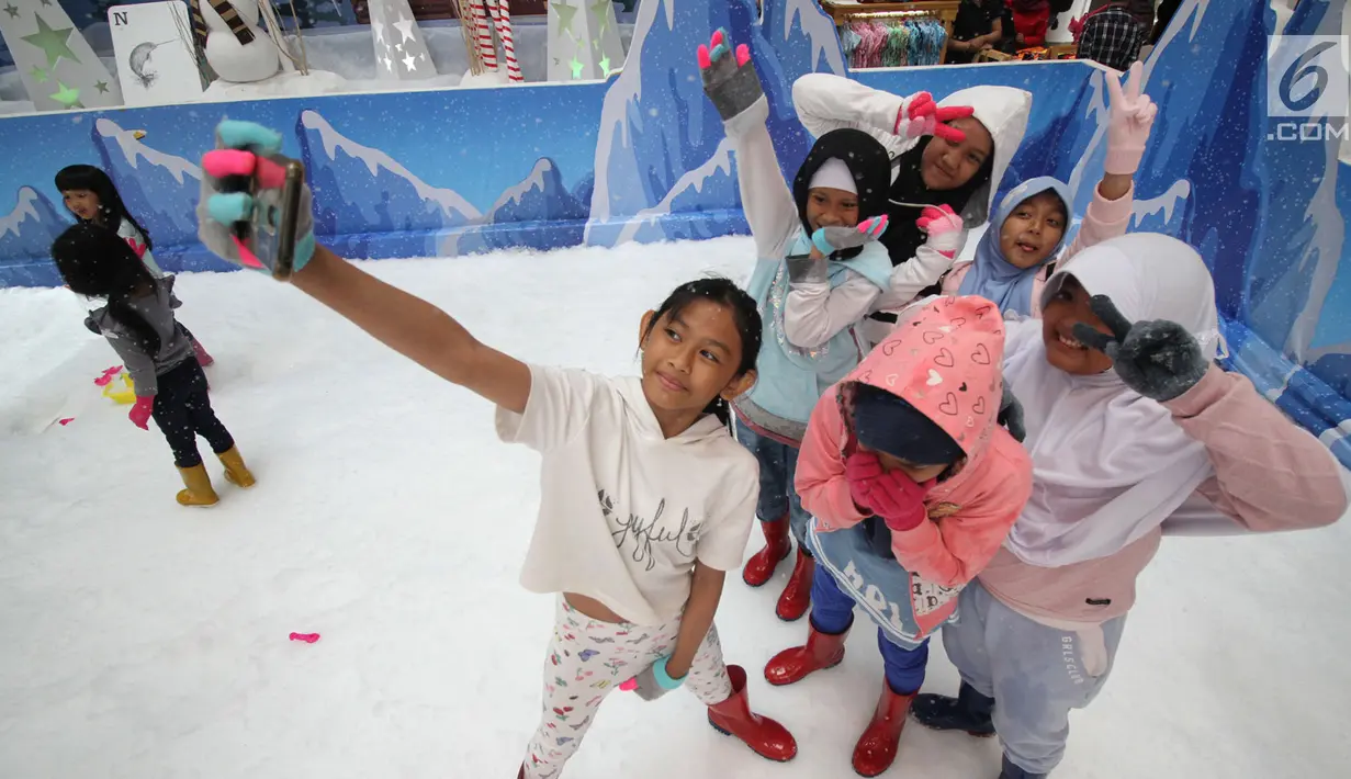 Anak-anak berselfie saat bermain sajlu di Snow Village di salah satu pusat perbelanjaan di kawasan Tangsel, Senin (17/12). Jelang Natal dan Tahun Baru sejumlah pusat perbelanjaan menyajikan kegiatan untuk menarik pengunjung. (Merdeka.com/Arie Basuki)