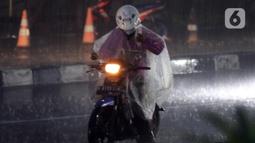 Pengendara motor mengenakan jas hujan saat melintas di kawasan Kuningan, Jakarta, Selasa (8/11/2022). Curah hujan yang tinggi di kawasan Jakarta berpotensi menimbulkan genangan atau banjir sehingga berpotensi memicu kemacetan, terutama saat jam kerja. (Liputan6.com/Helmi Fithriansyah)