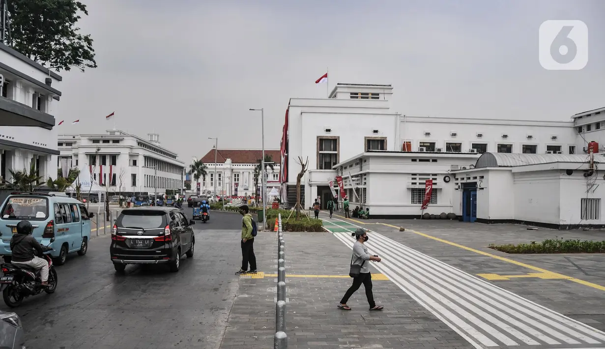 Pejalan kaki melintasi jalur pedestrian yang telah rampung dibangun di kawasan wisata Kota Tua, Jakarta Barat, Senin (22/8/2022). Proyek revitalisasi jalur pedestrian Kota Tua yang diharapkan dapat meningkatkan kenyamanan bagi pejalan kaki dan pengguna sepeda serta mewujudkan kawasan rendah emisi tersebut saat ini telah rampung dikerjakan. Pemprov DKI Jakarta rencananya akan meresmikan jalur pedestrian Kota Tua ini pada akhir Agustus mendatang. (merdeka.com/Iqbal S. Nugroho)