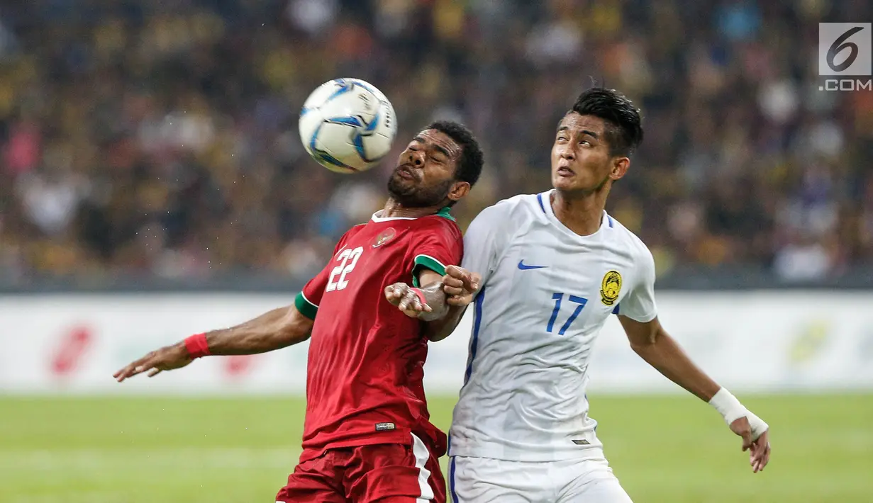 Pemain tuan rumah Malaysia berusaha merebut bola Pemain Timnas U-22 Yabes Roni pada pertandingan Sepak Bola Indonesia melawan Malaysia di Stadion Shah Alam, Selangor, Sabtu (26/08). (Liputan6.com/Faizal Fanani)