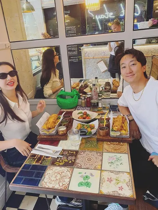 Menikmati makan siang bersama sahabat, Raline Shah mengenakan outfit monokrom yang kece. Ia mengenakan kemeja putih dengan lengan yang digulung dipadukan bawahan bermotif garis. (instagram/ralineshah)