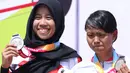 Atlet ParaCycling, Ni Mal Maghfiroh (pilot) dan Sri Sugiyanti (B) saat pengalungan medali nomor Womens B Road Race Asian Para Games 2018 di Sirkuit Sentul, Selasa (9/10). Ni Mal Maghfiroh dan Sri Sugiyanti meraih perak. (Liputan6.com/Helmi Fithriansyah)