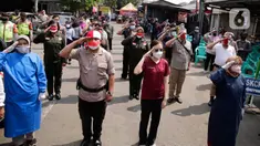 Ratusan masyarakat yang mengikuti vaksin Covid-19 memberi hormat saat memperingati HUT ke-76 RI di Jakarta, Selasa (17/8/2021). Hal tersebut dilakukan untuk mengenang jasa para pahlawan dalam memperjuangkan Kemerdekan Republik Indonesia. (Liputan6.com/Angga Yuniar)
