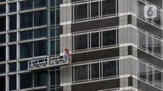 Pekerja membersihkan kaca gedung bertingkat di kawasan Sudirman Central Business District (SCBD), Jakarta, Senin (8/6/2020). Hampir tiga bulan kebijakan work from home (WFH) akibat pandemi COVID-19, banyak gedung bertingkat tidak terawat hari ini mulai dibersihkan. (merdeka.com/Dwi Narwoko)