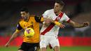 Striker Wolverhampton Wanderers, Raul Jimenez, berebut bola dengan bek Southampton, Jan Bednarek, pada laga lanjutan Liga Inggris di Molineux Stadium, Selasa (24/11/2020) dini hari WIB. Wolverhampton imbang 1-1 menghadapi Southampton. (AFP/Andrew Boyers/pool)