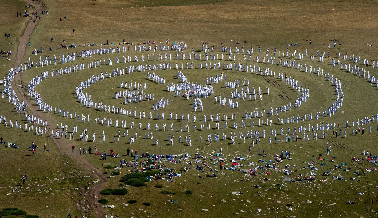 Anggota gerakan keagamaan internasional White Brotherhood menari di puncak Gunung Rila, Bulgaria, Senin (19/8/2019). Ratusan peziarah White Brotherhood yang berpakaian serba putih tersebut menggelar ritual untuk menyambut tahun baru "spiritual". (NIKOLAY DOYCHINOV/AFP)
