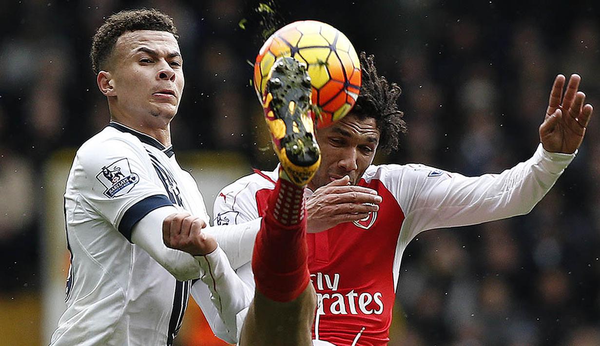7. Gelandang Arsenal, Mohamed Elneny, membuang bola dari jangkauan gelandang Tottenham, Dele Alli, pada laga Liga Premier Inggris di Stadion White Hart Lane, Sabtu (5/3/2016). Kedua tim bermain imbang 2-2. (AFP/Adrian Dennis)