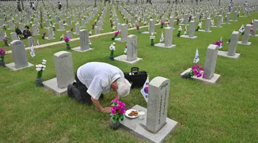 Seorang pria Korsel membungkuk memberi hormat di depan nisan kerabatnya yang gugur untuk negara pada Memorial Day di Pemakaman Nasional Seoul, Kamis (6/6/2019). Memorial Day didedikasikan untuk mengingat prajurit dan warga sipil yang gugur selama perang Korea antara 1950-1953. (Jung Yeon-je/AFP)