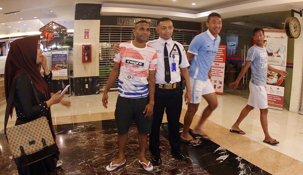 Seorang petugas keamanan mengajak berfoto pemain Sriwijaya FC, Titus Bonai di Hotel Bidakara jelang Final Piala Presiden 2015 melawan Persib, Minggu (18/10/2015). (Bola.com/Nicklas Hanoatubun)