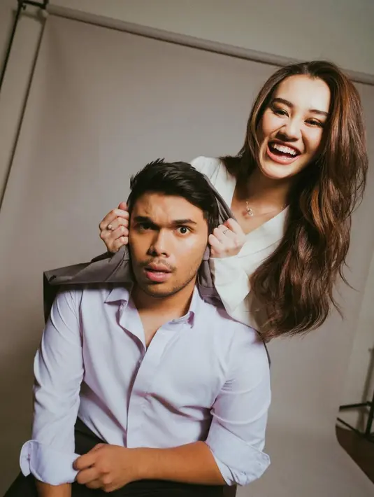 Pasutri ini sama-sama pakai kemeja bernuansa cerah dan celana panjang [@aaliyah.massaid]