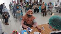 Petugas medis melakukan pemeriksaan kesehatan kepada warga calon penerima vaksin COVID-19 dosis ketiga di RSUD Tangerang Selatan, Rabu (12/1/2022). Lebih dari 60 warga lanjut usia (lansia) Tangsel mendapatkan vaksinasi lanjutan (booster) COVID-19 dengan jenis Pfizer. (merdeka.com/Arie Basuki)