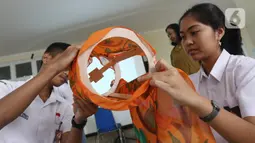 Siswa siswi membuat lampion bernuansa imlek di SMA Negri 39 Jakarta, Selasa (21/1/2020). Kerajinan lukisan tersebut dibuat oleh siswa untuk menyambut hari imlek 2571 yang jatuh pada Sabtu (25/1) 2020. (Liputan6.com/Herman Zakharia)