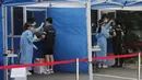 Petugas medis mengambil sampel dari petugas polisi selama pengujian COVID-19 di Badan Kepolisian Metropolitan Seoul di Seoul, Korea Selatan, Rabu, (19/8/2020). (AP Photo / Ahn Young-joon)
