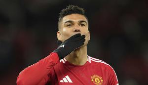 Gelandang Manchester United (MU), Casemiro, menyapa suporter di Old Trafford saat ditarik keluar dalam laga melawan Real Sociedad pada leg kedua 16 besar Liga Europa 2024/2025, Jumat (14/3/2025) dini hari WIB. (AP Photo/Dave Thompson)