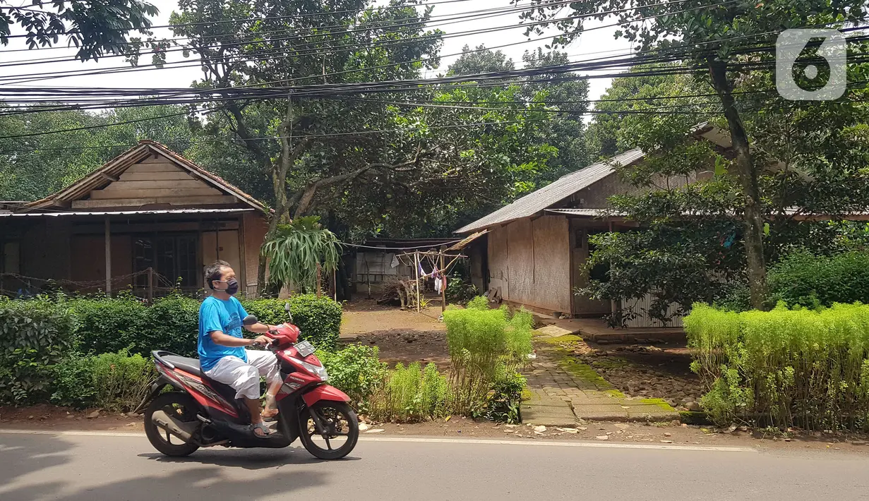 Warga melintas di lahan di RT 05/RW 05 Kelurahan Pondok Ranggon yang dikabarkan jadi lokasi pembangunan DP Rp 0, Jakarta Timur, Rabu (10/3/2021). KPK sedangmenyelidiki Program Rumah DP 0 Rupiah di Munjul, Kelurahan Pondok Ranggon, Kecamatan Cipayung, Jakarta Timur. (Liputan6.com/Herman Zakharia)