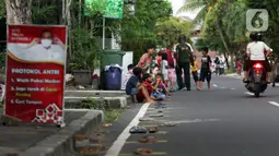 Sejumlah anak-anak antre untuk mendapat takjil gratis di Jalan Cempaka Putih Tengah XXI, Jakarta, Selasa (5/4/2022). Sekitar 200 paket berbuka yang merupakan donasi dari warga dan sejumlah organisasi dibagikan secara gratis selama bulan Ramadhan tahun ini. (Liputan6.com/Herman Zakharia)