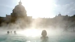 Orang-orang menikmati air hangat di kolam relaksasi Szechenyi, di Budapest, Hongaria pada 15 Februari 2019. Szechenyi Thermal Bath adalah salah satu lokasi pemandian umum tertua dan terbesar di Budapest. (VALERY HACHE / AFP)