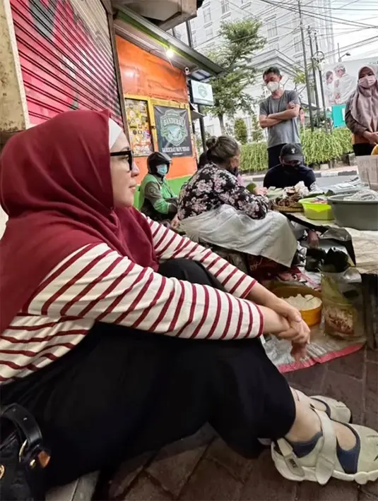Demi bisa menikmati lupis, Devi rela berangkat setelah salat subuh. Momen pemeran sinetron Sayap Cinta Terindah saat menunggu antrean duduk lesehan di pinggir jalan. [Instagram/devips]