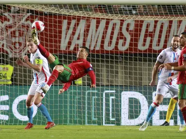 Penyerang Portugal Cristiano Ronaldo (tengah) mencoba mencetak gol dengan tendangan overhead ke gawang Luksemburg pada lanjutan Kualifikasi Piala Dunia 2022 di Stadion Do Algarve, Rabu (13/10/2021) dini hari WIB. Hat-trick Ronaldo membuat Portugal menang 5-0 atas Luksemburg. (AP Photo/Joao Matos)