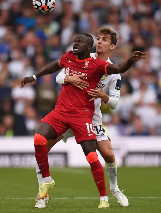 Pemain Leeds United Diego Llorente (kanan) berebut bola dengan pemain Liverpool Sadio Mane (tengah) pada pertandingan Liga Inggris di Elland Road, Leeds, Inggris, 12 September 2021. Liverpool menang 3-0. (Oli SCARFF/AFP)