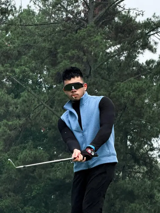 Tampilan penuh gaya Saaih dengan padu padan long sleeve top dan long pants serba hitam. Serta vest biru sebagai luaran.