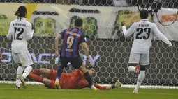 Penyerang Barcelona, Robert Lewandowski saat mencetak gol ke gawang Real Madrid pada final Piala Super Spanyol di Stadion King Fahd, di Riyadh, Arab Saudi, Senin (16/1/2023). Di pertandingan ini Lewandowski juga memberikan assist kepada Gavi yang mencetak gol. (AP Photo/Hussein Malla)