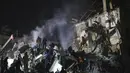 Pekerja darurat dan penduduk setempat membersihkan puing-puing setelah roket Rusia menghantam sebuah gedung apartemen di Kramatorsk, Ukraina, pada Kamis, 2 Februari 2023. Sedikitnya dua orang tewas akibat serangan roket tersebut. (AP Photo/Yevgen Honcharenko)