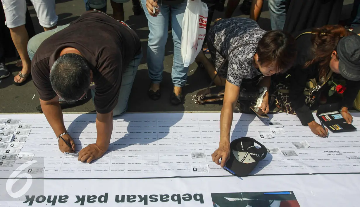 Para pendukung Ahok membubuhkan tandatangan saat aksi di depan Balaikota, Jakarta, Sabtu (13/5). Massa pendukung Ahok menggelar aksi pengumpulan KTP untuk membebaskan Ahok dari jeratan vonis dua tahun penjara. (Liputan6.com/Yoppy Renato)