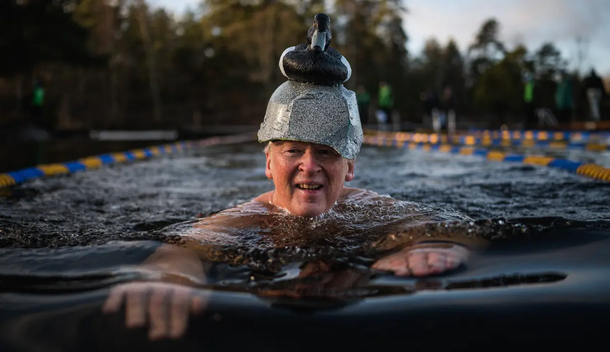 Seorang pria berpartisipasi dalam Kejuaraan Berenang Musim Dingin Swedia di Hellasgarden, Stockholm pada 5 Februari 2022. Kejuaraan renang tersebut digelar dengan suhu air tidak lebih dari 1,9 derajat celsius. (Jonathan NACKSTRAND / AFP)