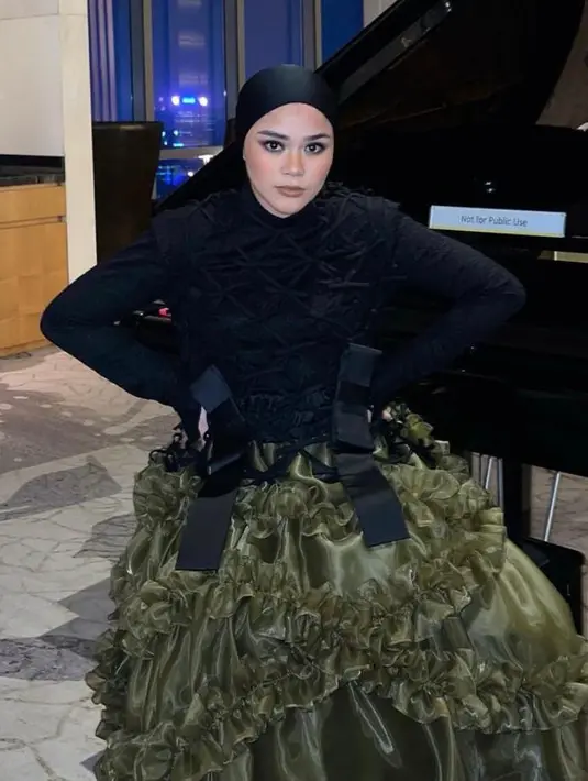 Saat manggung, Sivia Azizah memilih longsleeve top dan textured vest warna hitam senada. [@siviazizah].