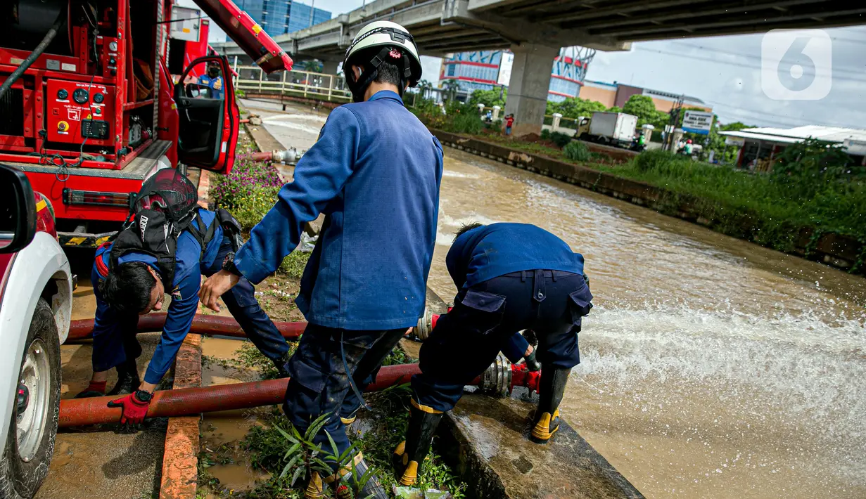 Petugas pemadan kebakaran menyedot air banjir di kawasan Cipinang Melayu, Jakarta, Minggu (21/2/2021). Suku Dinas Pemadam Kebakaran Jakarta Timur mengerahkan 20 mobil pompa untuk menyedot air yang membanjiri RW 04 Kelurahan Cipinang Melayu untuk mengurangi debit air. (Liputan6.com/Faizal Fanani)