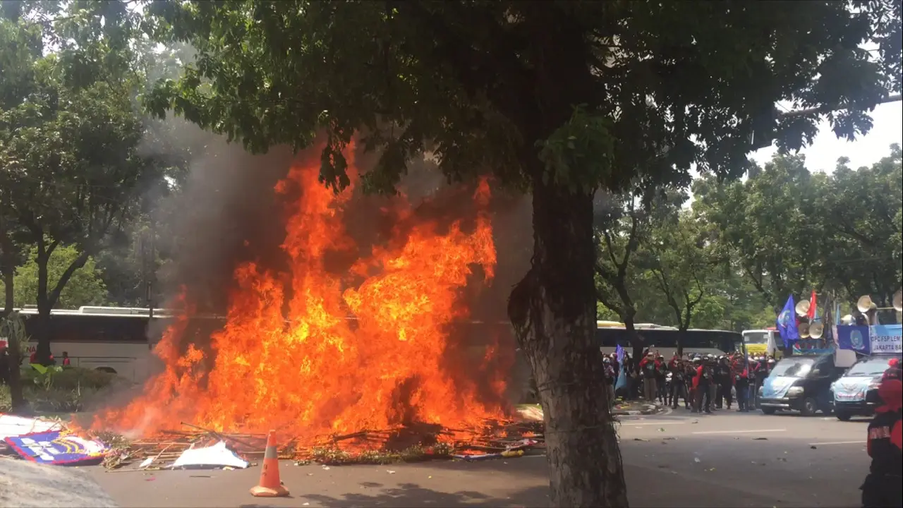 Pengunjuk rasa bakar karangan bunga untuk Ahok (Liputan6.com/Delvira Hutabarat)