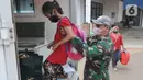 Anggota Kodiklat TNI membantu seorang anak menaiki kendaraan usai menjalani perawatan di Rumah Lawan Covid (RLC) di Tangerang Selatan, Kamis (5/8/2021). Dua pekan terakhir pasien Covid di RLC mengalami penurunan hingga 70 persen dari semula 300 pasien kini hanya 113 pasien. (merdeka.com/Arie Basuki)