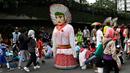 Boneka ondel-ondel berdiri diantara warga yang sedang beraktivitas di lokasi car free day, Jakarta, Minggu (21/5). (Liputan6.com/Immanuel Antonius)