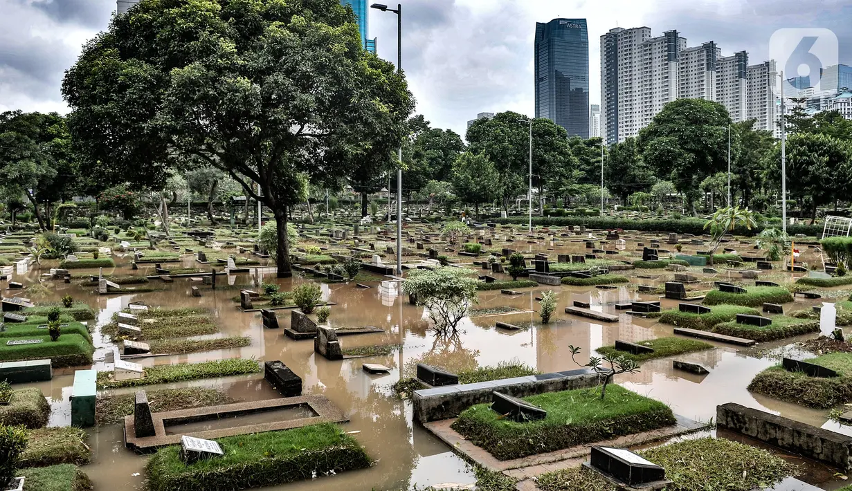 Kondisi Taman Pemakaman Umum (TPU) Karet Bivak, Jakarta, saat terendam banjir, Minggu (7/2/2021). Hujan deras yang mengguyur sejak Minggu dinihari menyebabkan tiga blok di kompleks pemakaman TPU Karet Bivak terendam banjir hingga ketinggian mencapai 30 sentimeter. (merdeka.com/Iqbal Nugroho)