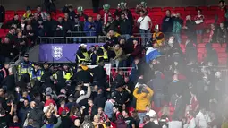Suporter Hungaria bentrok dengan polisi saat dimulainya laga Kualifikasi Piala Dunia 2022 melawan Inggris di Stadion Wembley, Rabu (13/10/2021) dini hari WIB. Bentrokan terjadi saat polisi berusaha menangkap penonton yang melakukan pelecehan rasial terhadap petugas stadion. (Nick Potts/PA via AP)
