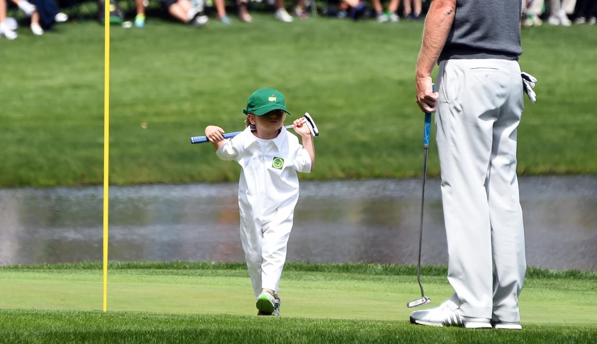 Austin, putri dari pegolf Brandt Snedeker berjalan saat mengikuti acara Masters Par 3 Tournament di Augusta National Golf Club, Georgia, (5/4). Anak-Anak ini menunjukkan keterampilannya bermain golf bersama orang tuanya. (AFP Photo/Jim Watson)
